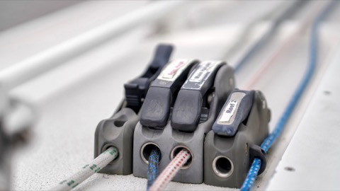 Photo of the Pegasus Racing J-E100 — Port cabin top halyard and control clutches, reef line, 2nd spin halyard, main halyard, 2nd reef line, and cunningham